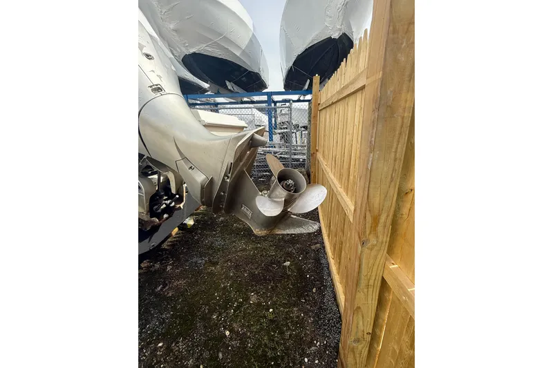 Slide: The Image of Outboard motor of 2002 Wellcraft 22 Coastal Walkaround near wooden fence. - 15