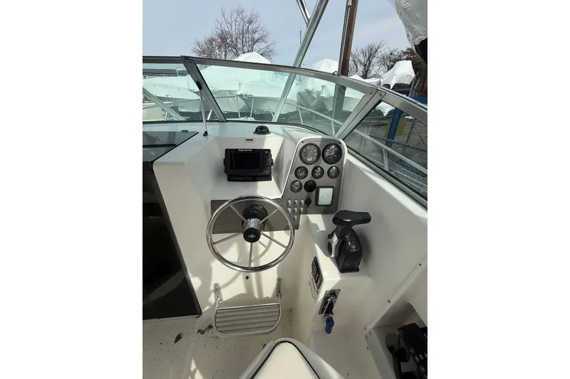 Slide: The Image of 2002 Wellcraft 22 Coastal Walkaround O/B helm with steering wheel and instrument panel. - 7