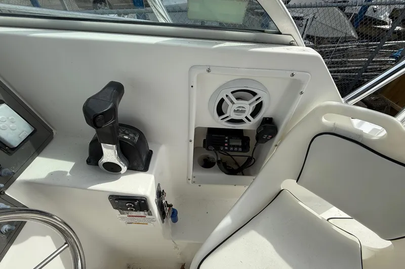 Slide: The Image of 2002 Wellcraft 22 Coastal Walkaround O/B helm with controls, speaker, and radio equipment. - 8
