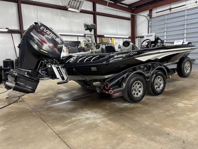 Slide: The Image of Black 2013 Ranger 520C boat in a garage setting. - 3
