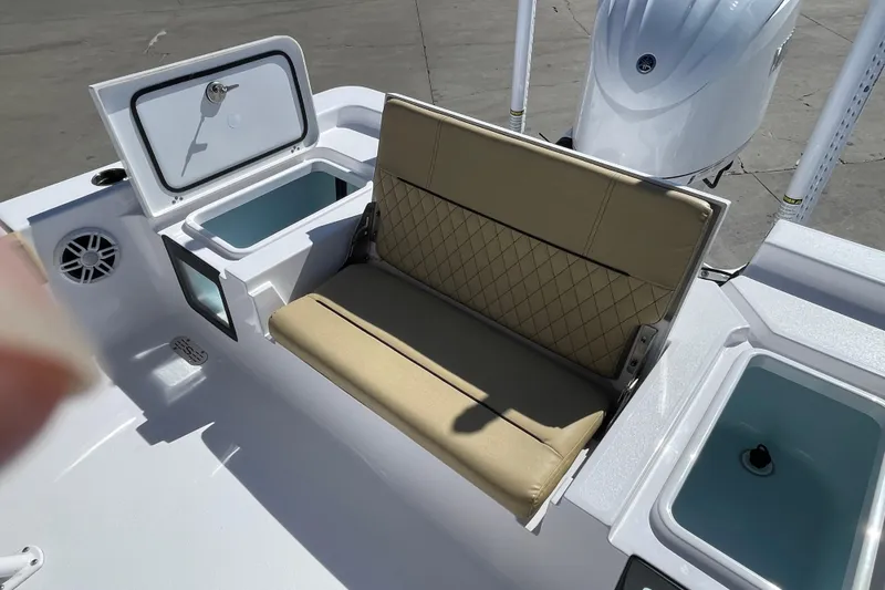 Slide: The Image of 2024 Sportsman Masters 247 Bay Boat interior with tan seating and storage compartments. - 14