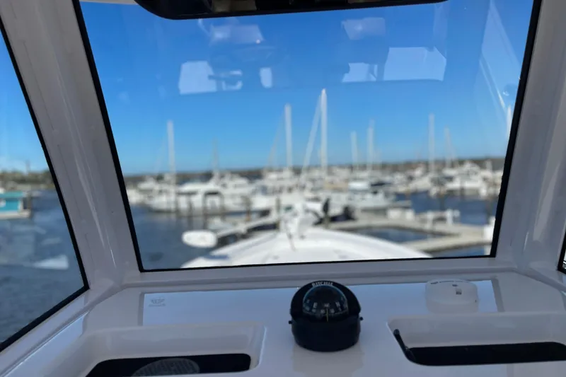 Slide: The Image of 2024 Sportsman Masters 247 Bay Boat dashboard view overlooking marina with boats. - 15