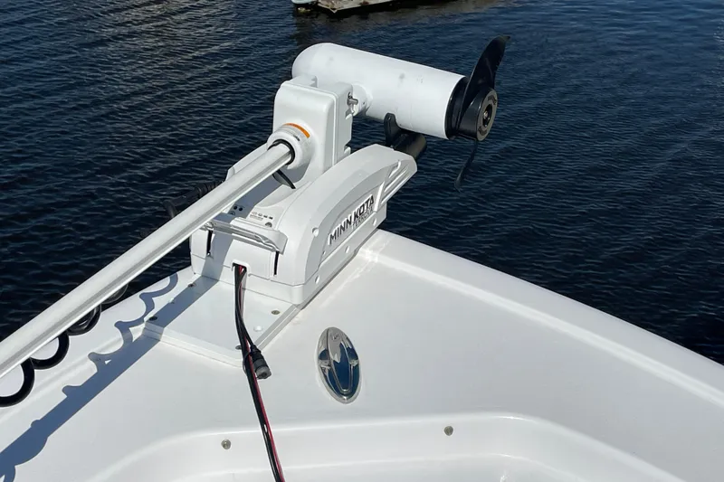 Slide: The Image of 2024 Sportsman Masters 247 Bay Boat with Minn Kota trolling motor on calm water. - 18