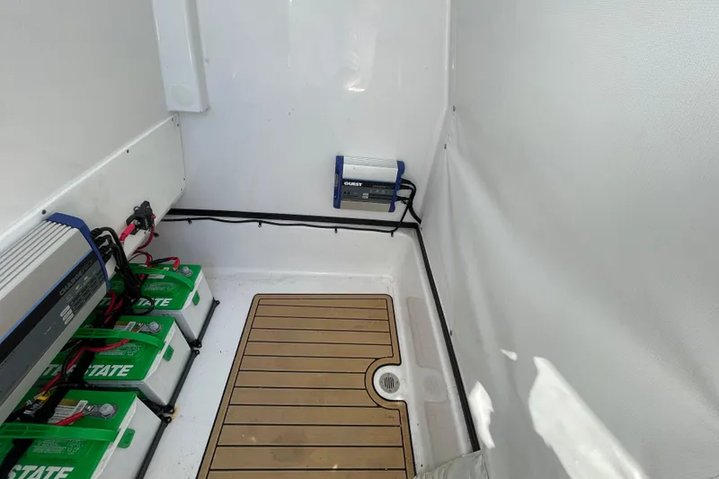 Slide: The Image of 2024 Sportsman Masters 247 Bay Boat battery compartment with neatly arranged batteries and wiring. - 27