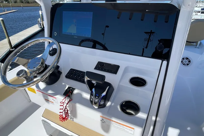 Slide: The Image of 2024 Sportsman Masters 247 Bay Boat dashboard with steering wheel and control panel. - 7