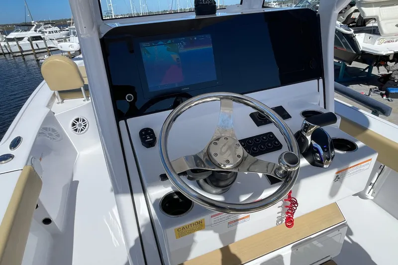 Slide: The Image of 2024 Sportsman Masters 247 Bay Boat helm with steering wheel and navigation display. - 8