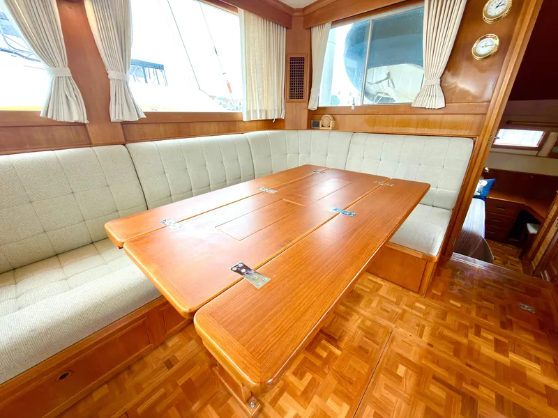 Slide: The Image of Interior of a 2003 Grand Banks Classic yacht with wooden table and cushioned seating. - 18