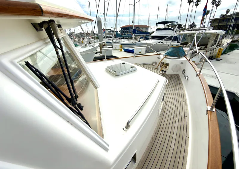 Slide: The Image of 2003 Grand Banks Classic yacht in harbor, featuring wooden deck and window details. - 5