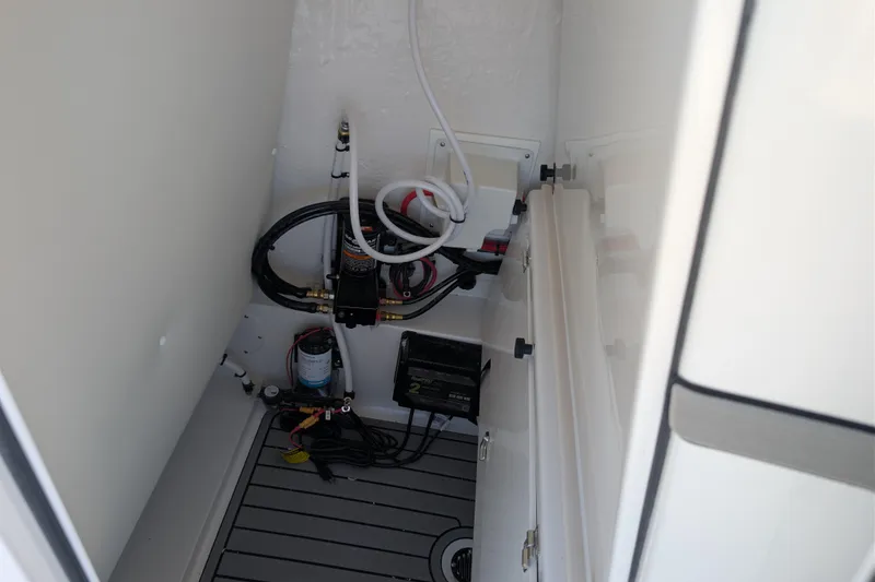 Slide: The Image of Interior view of 2026 Tidewater 2410 Bay Max boat compartment with wiring and equipment. - 10