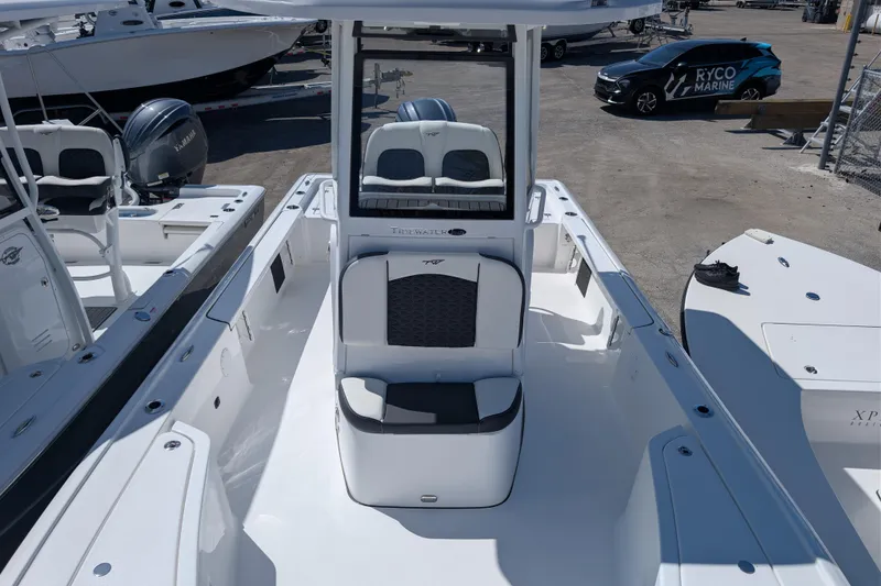 Slide: The Image of 2026 Tidewater 2410 Bay Max boat interior with seating and console, displayed outdoors. - 5
