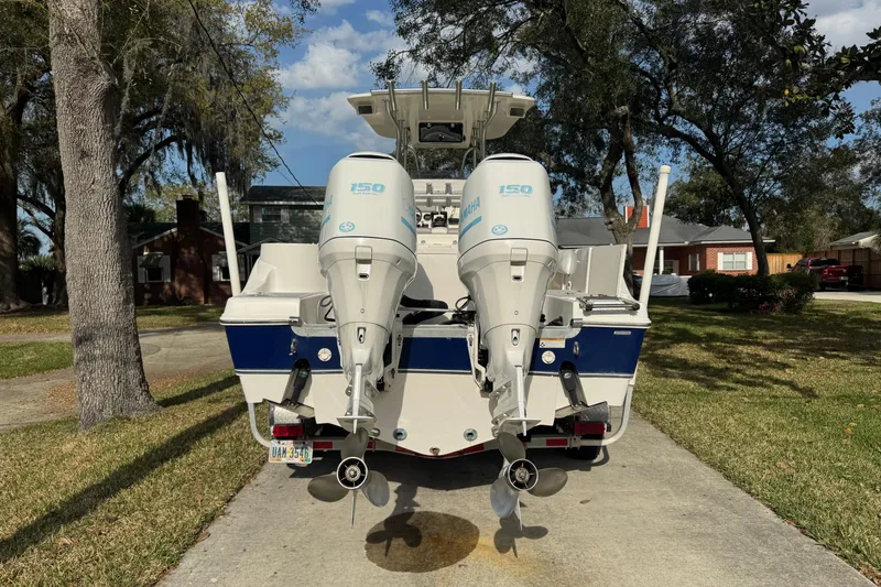 Slide: The Image of 2012 NauticStar 2500XS Offshore boat with dual Yamaha 150 engines, parked in driveway. - 6