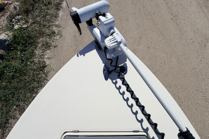 Slide: The Image of 2021 Maverick 18 HPX-V boat with mounted trolling motor on sandy terrain. - 17