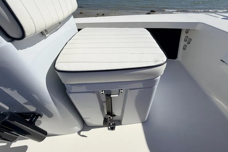 Slide: The Image of 2021 Maverick 18 HPX-V boat seat with white cushioned top, near water. - 25