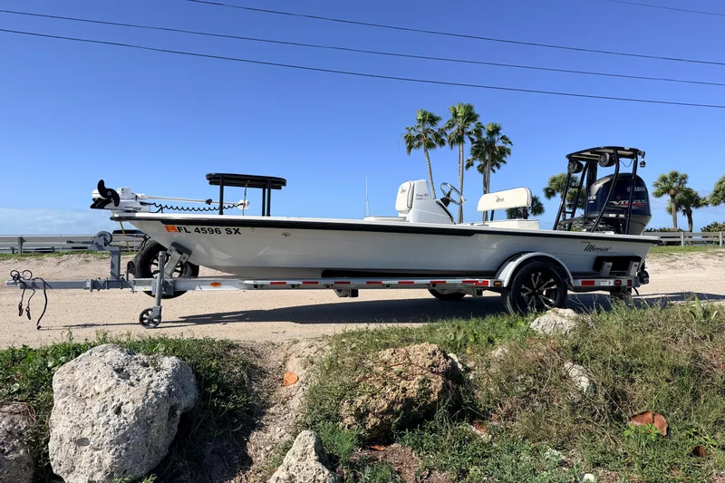 Slide: The Image of 2021 Maverick 18 HPX-V boat on trailer, parked near palm trees under clear blue sky. - 4