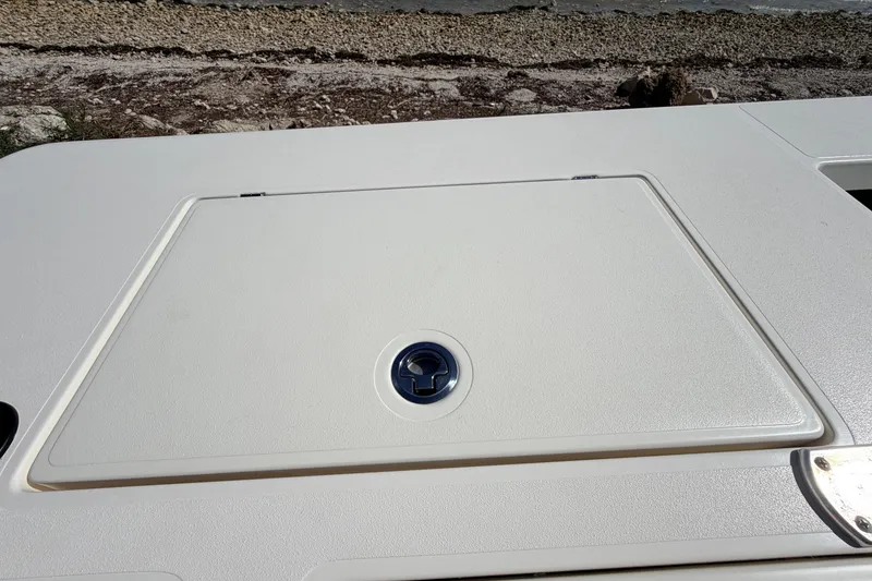 Slide: The Image of 2021 Maverick 18 HPX-V boat hatch cover on deck, near rocky shoreline. - 48