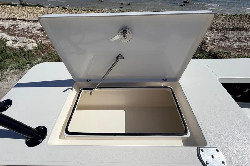 Slide: The Image of Open storage compartment on 2021 Maverick 18 HPX-V boat, near rocky shoreline. - 49