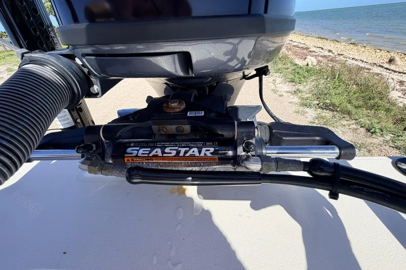 Slide: The Image of Close-up of SeaStar steering system on 2021 Maverick 18 HPX-V boat by the shore. - 54