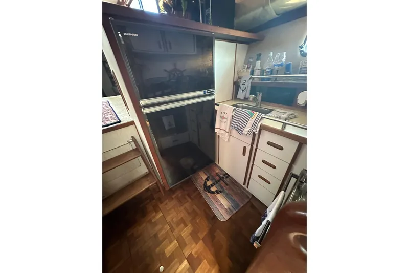 Slide: The Image of Interior of 1985 Carver 3207 Aft Cabin Motor Yacht kitchen area with fridge and cabinets. - 10