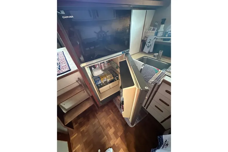 Slide: The Image of Interior of 1985 Carver 3207 Aft Cabin Motor Yacht with open fridge and kitchen area. - 11