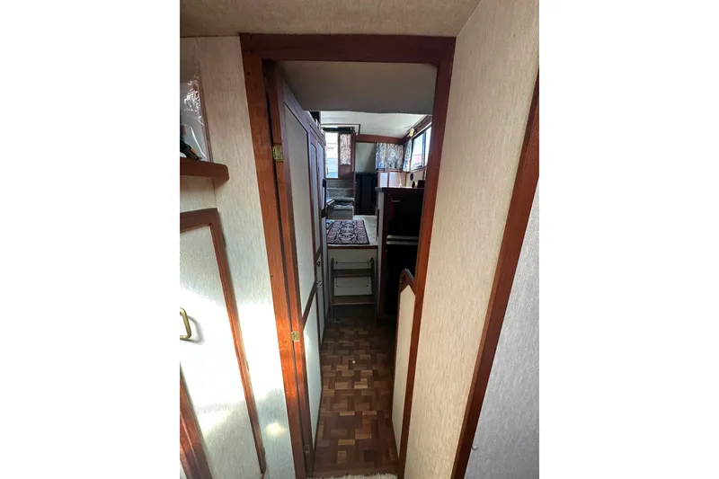 Slide: The Image of 1985 Carver 3207 Aft Cabin Motor Yacht interior hallway with wood accents and parquet flooring. - 15