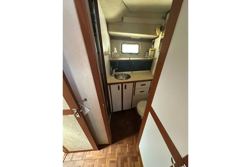 Slide: The Image of 1985 Carver 3207 Aft Cabin Motor Yacht bathroom with sink, toilet, and window. - 17