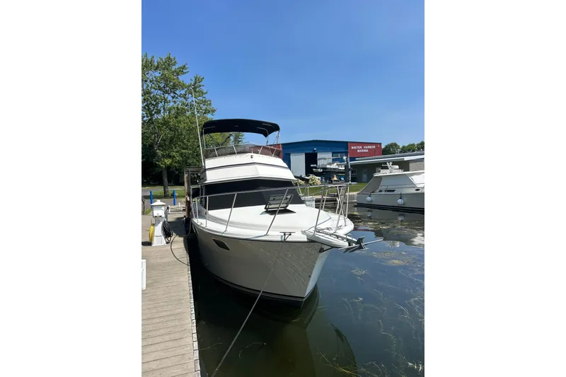 Slide: The Image of 1985 Carver 3207 Aft Cabin Motor Yacht docked at marina under clear blue sky. - 2