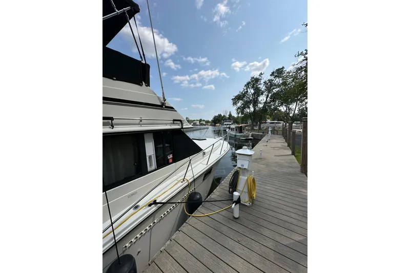 Slide: The Image of 1985 Carver 3207 Aft Cabin Motor Yacht docked at marina under clear sky. - 5