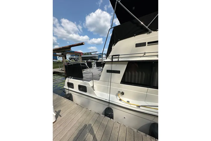 Slide: The Image of 1985 Carver 3207 Aft Cabin Motor Yacht docked under blue sky. - 6