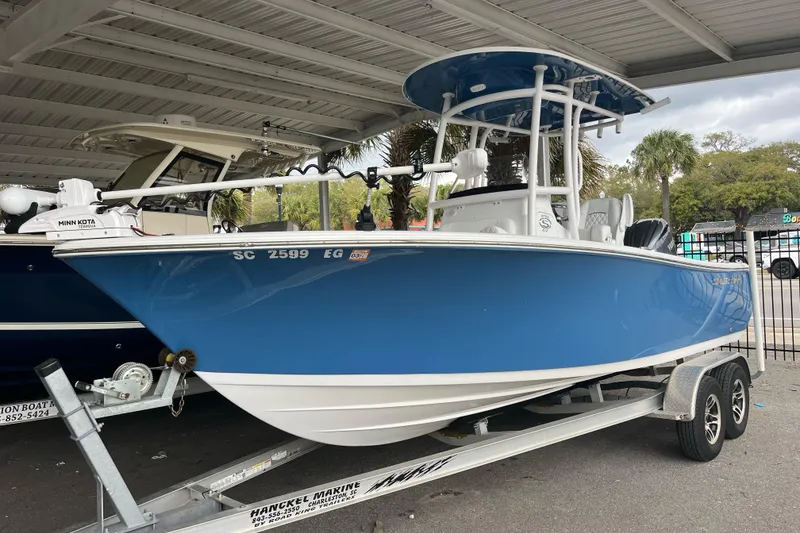 The Image of 2024 Sportsman Open 212 Center Console boat in blue on a trailer. - 0