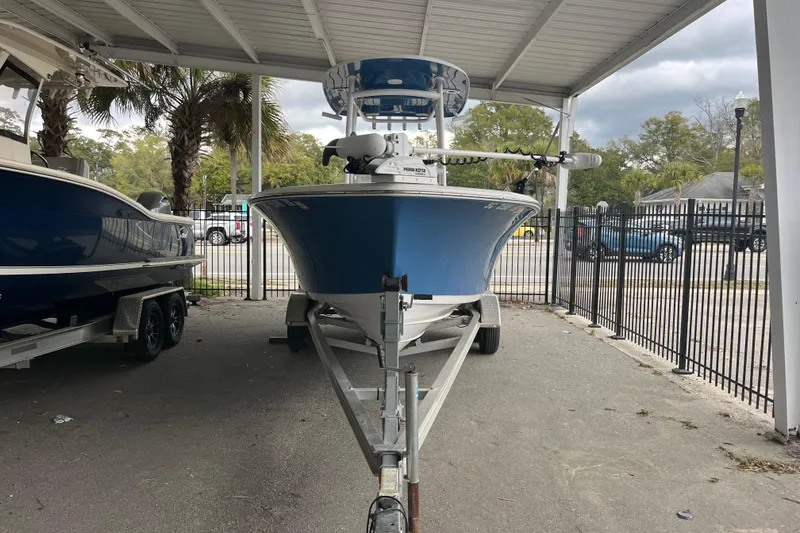 Slide: The Image of 2024 Sportsman Open 212 Center Console boat on trailer under shelter. - 2