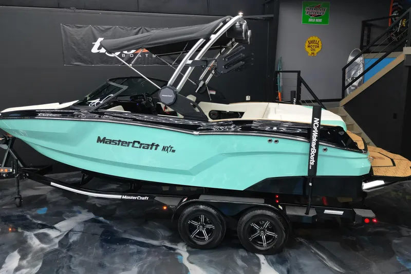 Slide: The Image of 2024 MasterCraft NXT21 boat in showroom, featuring sleek design and vibrant color. - 14