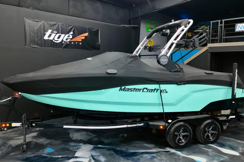 Slide: The Image of 2024 MasterCraft NXT21 boat with cover on trailer in showroom. - 17
