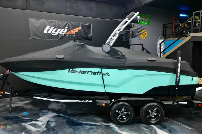 Slide: The Image of 2024 MasterCraft NXT21 boat with cover on trailer in showroom. - 5