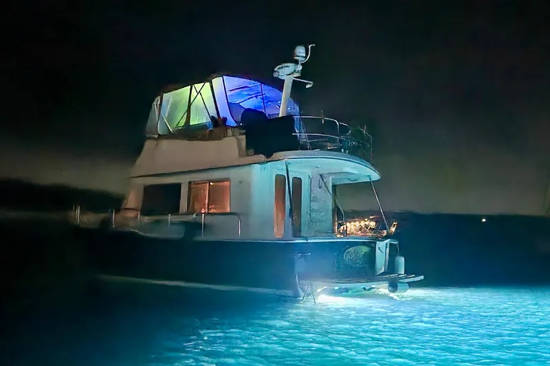 Slide: The Image of 2008 Mainship 34 Trawler illuminated at night on the water. - 10