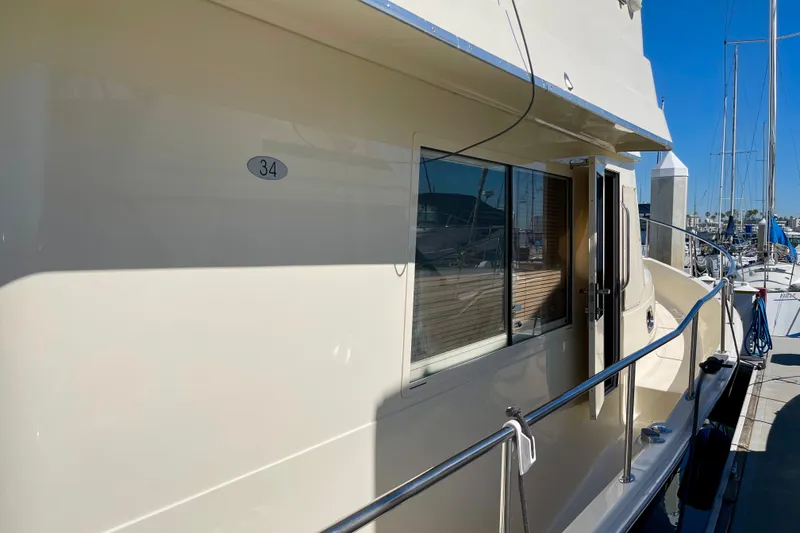 Slide: The Image of 2008 Mainship 34 Trawler docked at marina, side view with open door. - 11