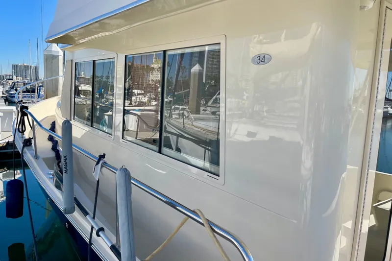 Slide: The Image of 2008 Mainship 34 Trawler docked at marina, showcasing sleek exterior design. - 12