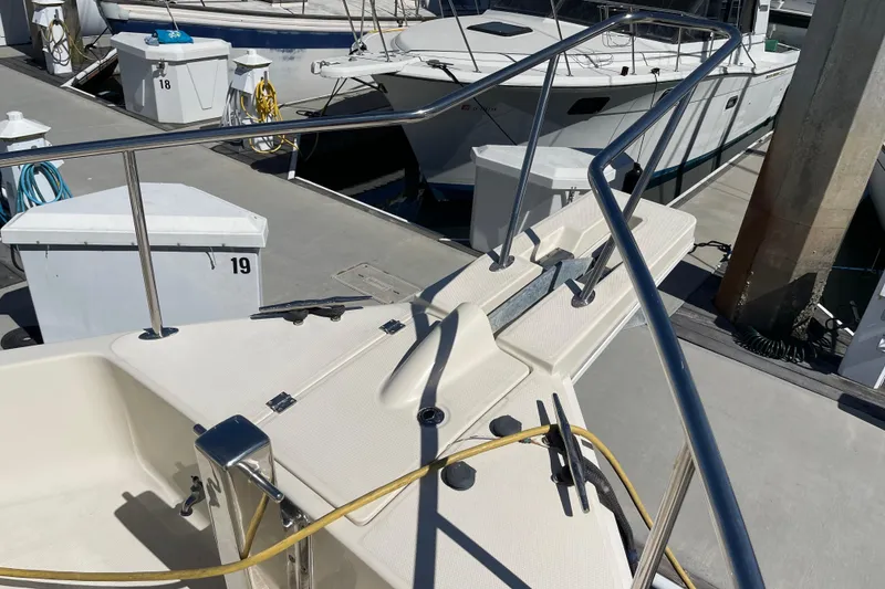 Slide: The Image of 2008 Mainship 34 Trawler docked at marina, showing deck and railing details. - 15