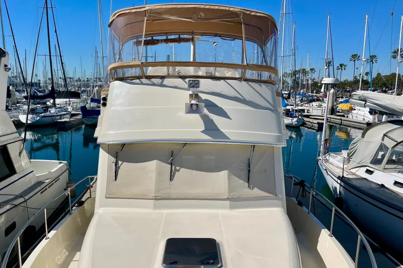 Slide: The Image of 2008 Mainship 34 Trawler docked in a marina with sailboats in the background. - 16