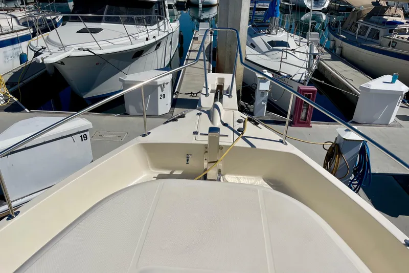 Slide: The Image of 2008 Mainship 34 Trawler docked at marina, surrounded by other boats. - 19