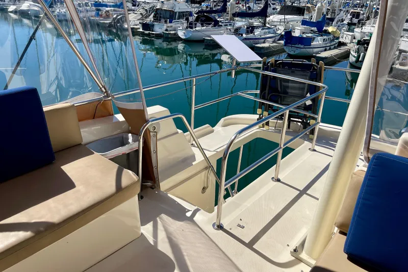 Slide: The Image of 2008 Mainship 34 Trawler deck with seating, overlooking marina with boats. - 23