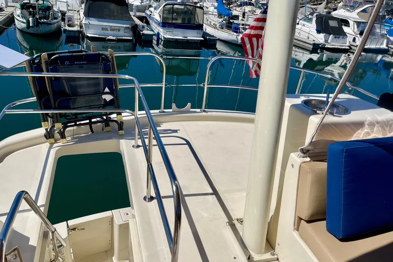 Slide: The Image of 2008 Mainship 34 Trawler deck view with marina backdrop and American flag. - 24