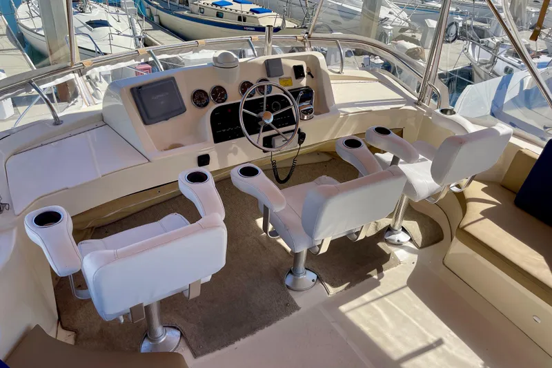 Slide: The Image of 2008 Mainship 34 Trawler helm with four white captain chairs and navigation controls. - 30