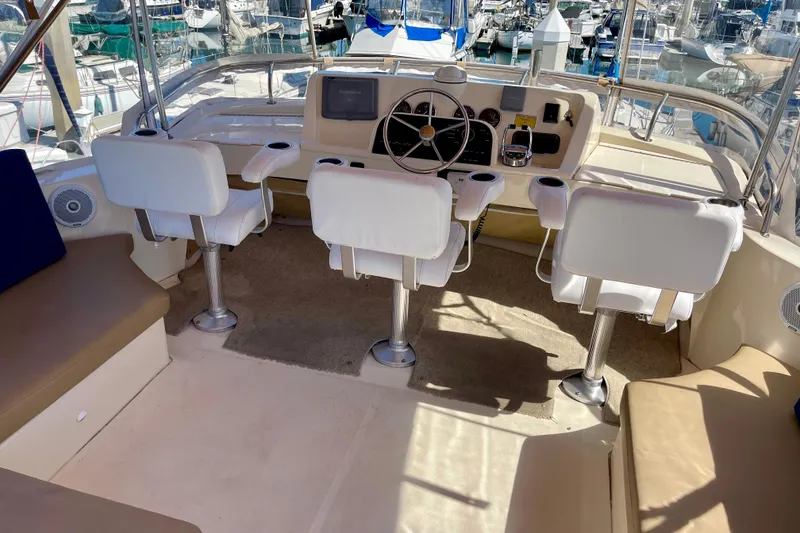 Slide: The Image of 2008 Mainship 34 Trawler helm with white seating, docked at marina. - 32