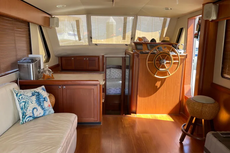 Slide: The Image of Interior of 2008 Mainship 34 Trawler with wooden helm and cozy seating area. - 34