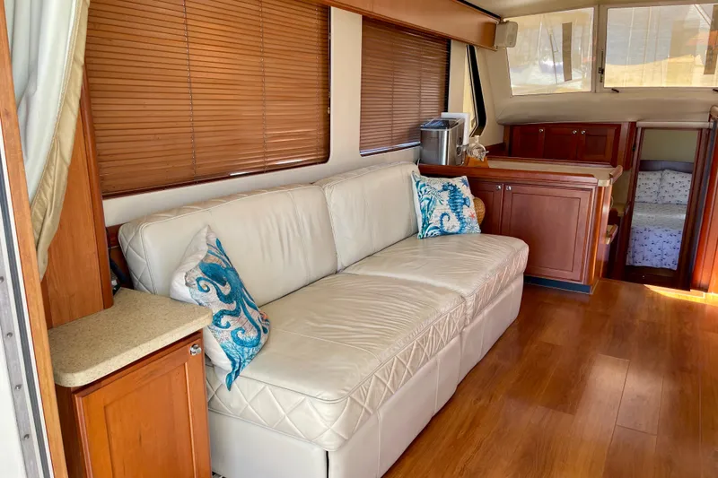 Slide: The Image of Interior of 2008 Mainship 34 Trawler with white sofa, wooden cabinets, and decorative pillows. - 35