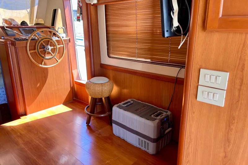 Slide: The Image of Interior of 2008 Mainship 34 Trawler with wooden helm, stool, and storage box. - 36