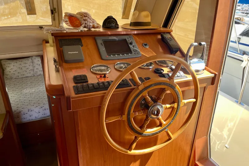 Slide: The Image of Wooden helm station of 2008 Mainship 34 Trawler with navigation instruments and decor. - 37