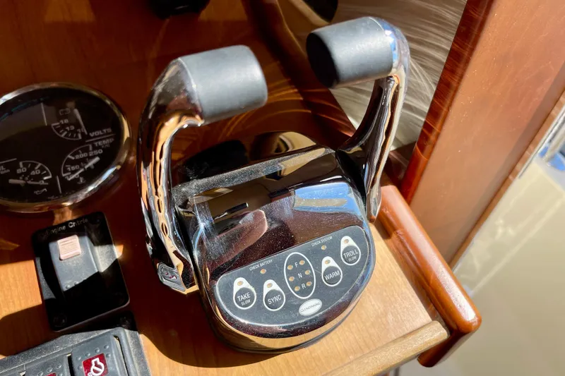 Slide: The Image of Throttle controls on a 2008 Mainship 34 Trawler dashboard, featuring gauges and switches. - 40