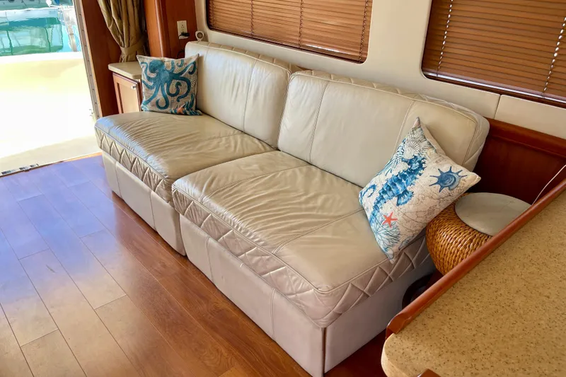 Slide: The Image of Luxurious interior of 2008 Mainship 34 Trawler with leather sofa and nautical-themed pillows. - 41