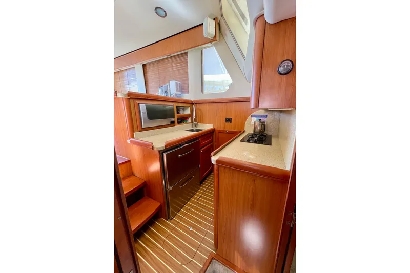 Slide: The Image of 2008 Mainship 34 Trawler interior kitchen with wood cabinetry and modern appliances. - 49